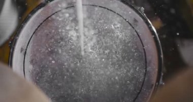 Davulun üst görünümü her yöne uçan davul ve su damlaları vurdu.