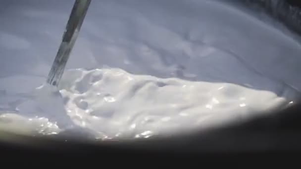 Suntikan makro mencampur cat putih dengan bor di ember — Stok Video
