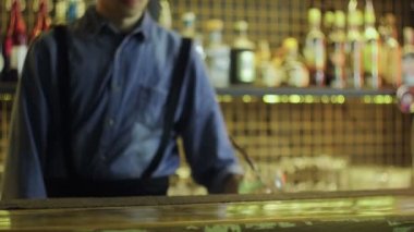 Mavi gömlekli barmen barın kenarına bitmiş bir kokteyl koydu.