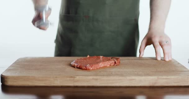 Повар бьет мясо на доске — стоковое видео