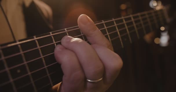 Primer plano de los dedos tocando una guitarra . — Vídeos de Stock