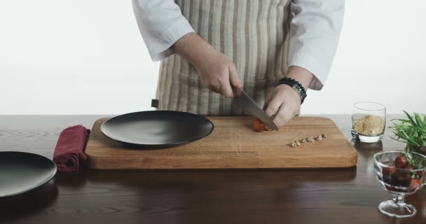 Koken zorgvuldig snijdt aardbeien op een snijplank — Stockvideo