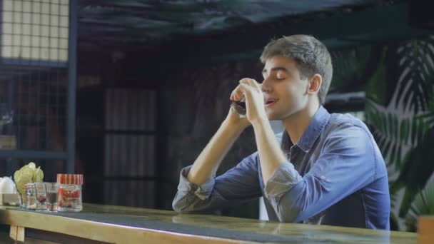 Jeune homme parlant sur son portable et buvant de l'alcool — Video