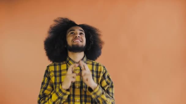 Dua eden Afrikalı Amerikalı adamın portresi parmaklarını çapraz tutuyor ve Tanrı 'nın çığlığı turuncu arka planda lütfen. Duyguların kavramı — Stok video