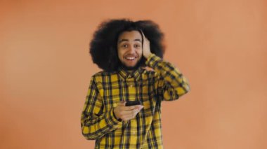 Genç mutlu Afrikalı işadamı telefonu kullanıyor ve Orange hakkında iyi haberler alıyor. Duyguların kavramı