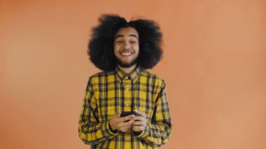 Genç mutlu Afrikalı işadamı telefonu kullanıyor ve Orange hakkında iyi haberler alıyor. Duyguların kavramı