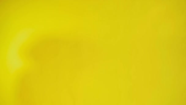 Attraente afro americano maschio che cammina sullo sfondo giallo nella cornice di ripresa, sorridendo e agitando la mano ciao davanti alla telecamera e andando via — Video Stock
