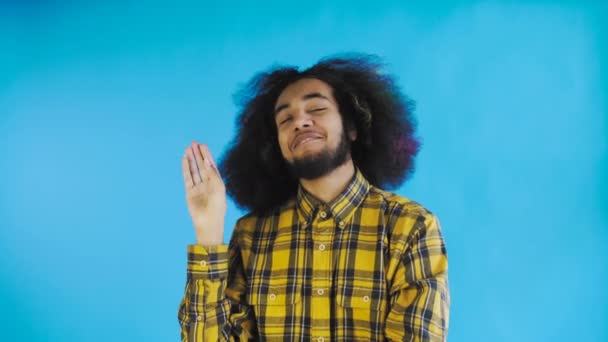 Genç Afro-Amerikalı bir adam sessizliğini koruyor ya da mavi arka planda bla bla jest yapıyor. Duyguların kavramı — Stok video