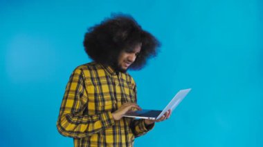 Laptopta yazan Afro-Amerikalı bir adam. Hayır, Sallanan Kafa tarafından. Mavi arka planda. Duyguların kavramı