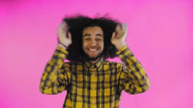 Endişeli Afro-Amerikalı Adam gülüyor, ellerini yüzüne dikiyor ve Mor Arkaplanda Başarı Kutlaması.