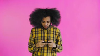Afro-Amerikalı adam mor arka planda Smartphone 'da oyun oynuyor. Duyguların kavramı