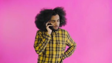 Mor arka planda cep telefonuyla konuşan mutlu Afro-Amerikalı adam. Duyguların kavramı