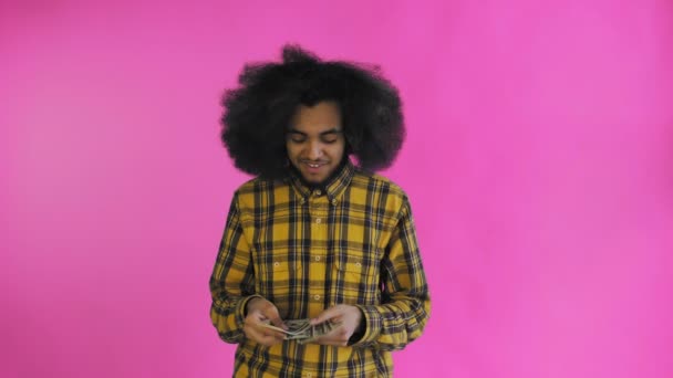 若いアフリカ系アメリカ人男性カウント現金お金に紫の背景. — ストック動画
