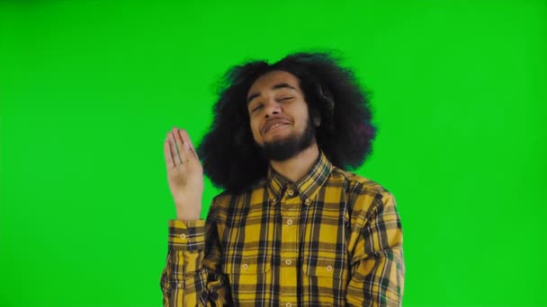 Young Afro-American man showing silence or bla bla gesture on green screen or chroma key background. Concept of emotions — Stock Video