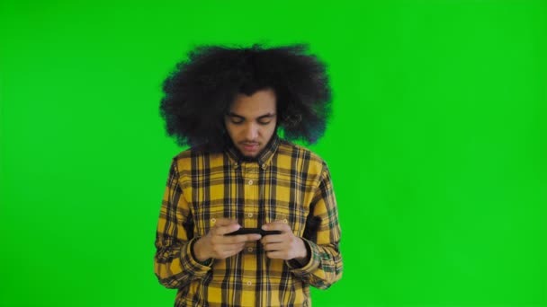 Afro-American Man Gioco su Smartphone su schermo verde o sfondo chiave cromatica. Concetto di emozioni — Video Stock