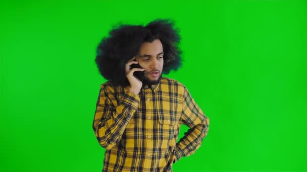 Feliz atractivo joven afroamericano hablando en el teléfono móvil en la pantalla verde o croma clave de fondo. Concepto de emociones — Vídeos de Stock