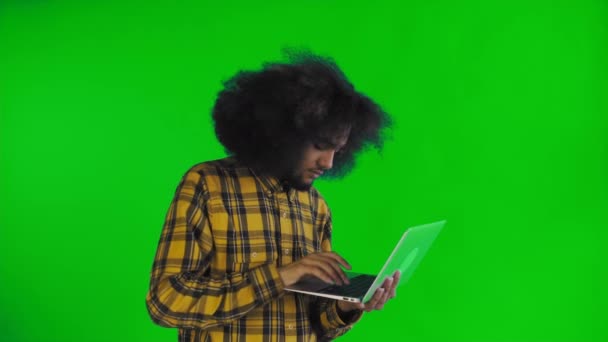 Gelukkig African American man met behulp van laptop op groen scherm of Chroma Key achtergrond. Concept van emoties — Stockvideo