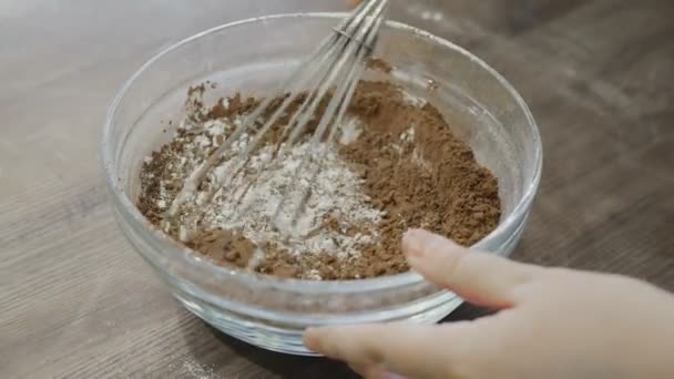 Шеф-повар смешивает порошок какао с мукой в миске — стоковое видео