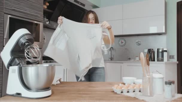 Una mujer usando un delantal para cocinar comida. Vestido y corbata un delantal de cocina blanco — Vídeos de Stock