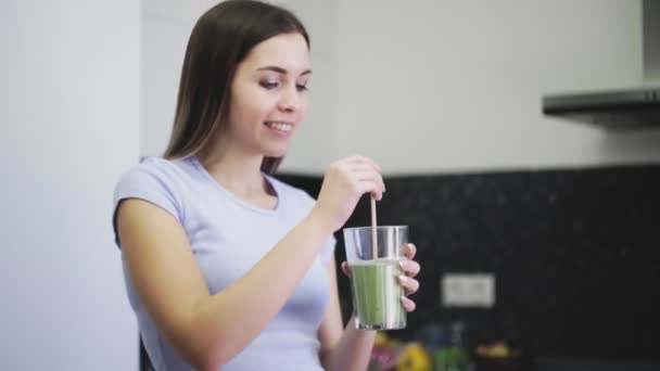 Mulher está bebendo smoothie de legumes de frutas com leite através de uma palha — Vídeo de Stock