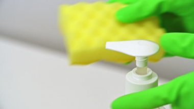 el yeşil eldiven itme dispenseri ve sıvı deterjan sarı sünger sıkılmış