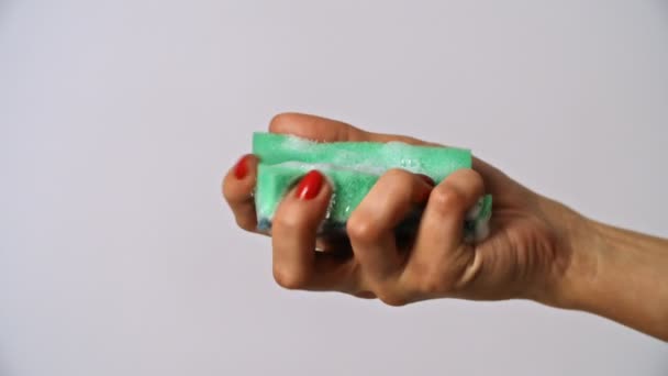 Женщина сжимает зеленую губку в руке — стоковое видео