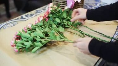 Çiçekçi elleri çiçekçide modern buket yapıyor.