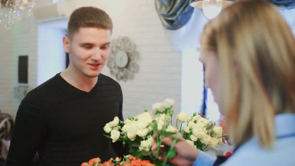 Cliente está cheirando uma flor em uma loja para fazer a escolha — Vídeo de Stock