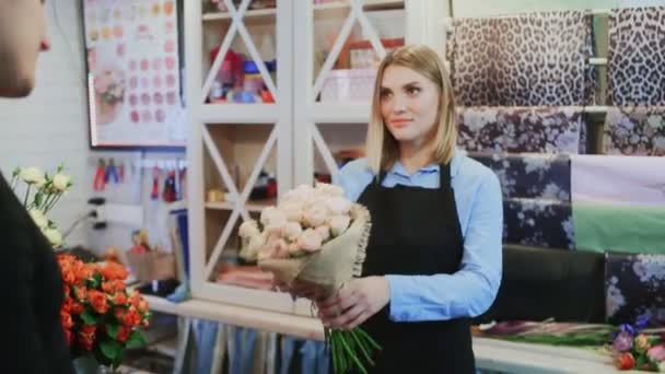 Дівчина флорист продає букет власнику магазину Чоловік флорист — стокове відео