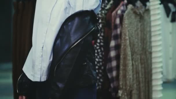 Chica probándose una chaqueta de cuero en la tienda . — Vídeos de Stock