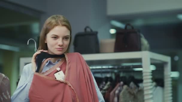 Femme essayant des vêtements dans le magasin de vêtements. Faire choisir betvine rouge et — Video