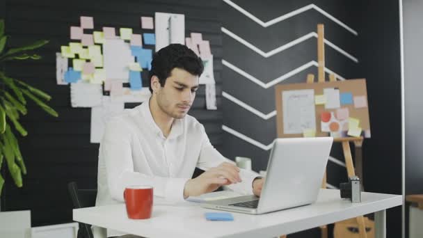 L'homme éteint son ordinateur portable et boit du café — Video