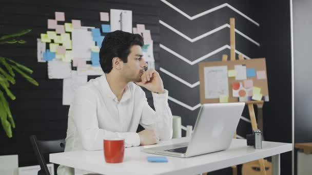 Hombre de negocios guapo mirando a la ventana y luego empezar a trabajar — Vídeo de stock