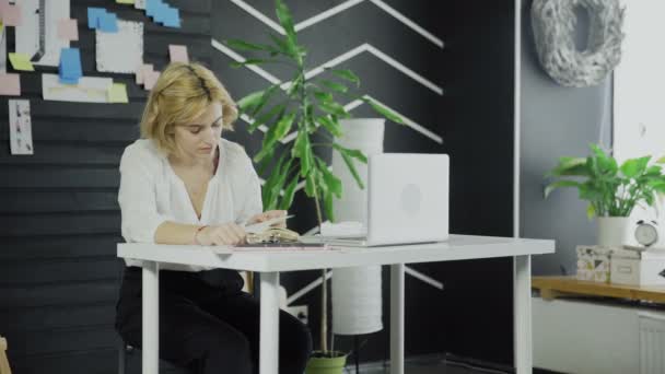 Pretty girl sitting and reading book in office — Stock Video