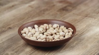 Bir kadın, kasesinden yemek için tek bir fıstıklı alır. Sağ tarafıma fındık kaçtı.