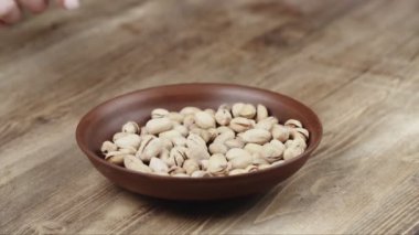 Bir kadın, kasesinden yemek için tek bir fıstıklı alır. Sol tarafıma fındık kaçtı.