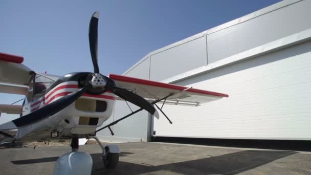 Aereo bianco e rosso vicino all'hangar — Video Stock