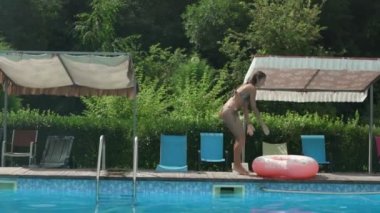 Havuz yaz güzel genç kadın. Bikini kız şişme donut daire ile tropikal havuz yakınında yürüyüş