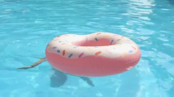 A nő jól érzi magát egy felfújható fánk körrel a medencében. — Stock videók