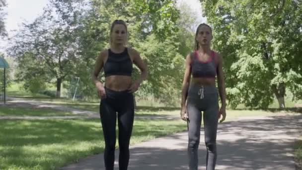 Dos mujeres deportivas corriendo en el parque — Vídeos de Stock