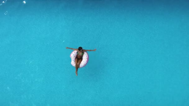 Jeune femme heureuse se détendre sur jouet de piscine gonflable dans la piscine bleue le jour ensoleillé — Video