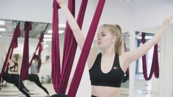 Jonge Kaukasische vrouw maken antizwaartekracht vliegen yoga oefeningen in hangmat — Stockvideo