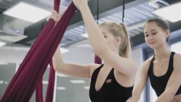 I gym kvinna sträcker ut sina ben på hängmatta ovanför golvet. — Stockvideo