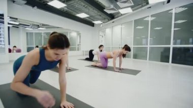 Yoga alıştırma sınıfı konsepti. Antrenör alıştırmaları gösterir