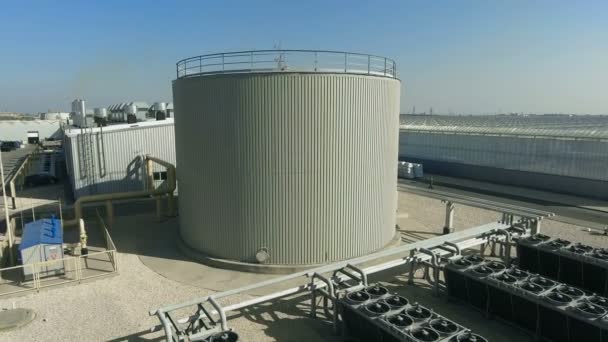 Depósito de agua y aire acondicionado industrial cerca de invernadero — Vídeo de stock