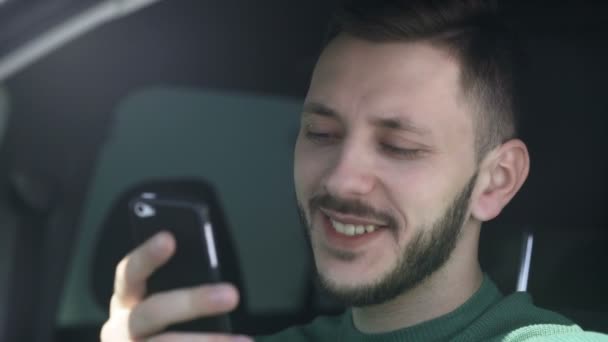 Close-up tiro de um homem brutal conversando em um telefone sentado no carro . — Vídeo de Stock