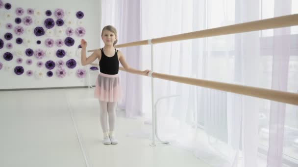 Pretty little ballet dancer is waving her hand — Stock Video