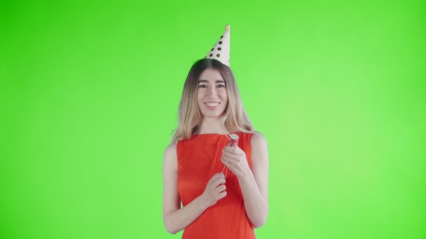 Mujer joven explotando galleta confeti en una pantalla verde  . — Vídeos de Stock