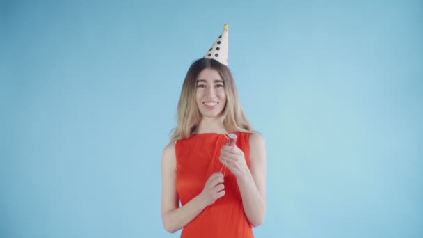 Fiatal nő felrobban konfetti keksz egy kék háttér. — Stock videók