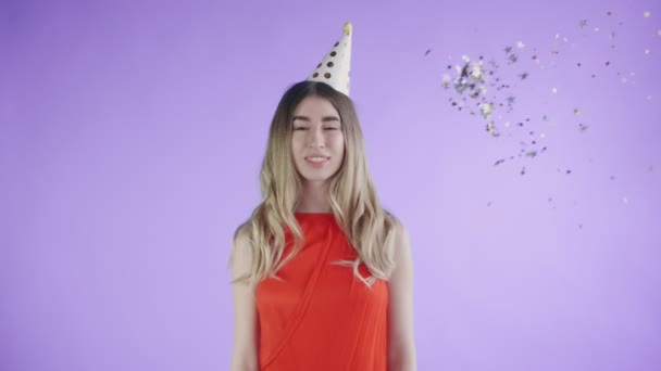 Confetti foi atirado para a menina em um fundo roxo . — Vídeo de Stock